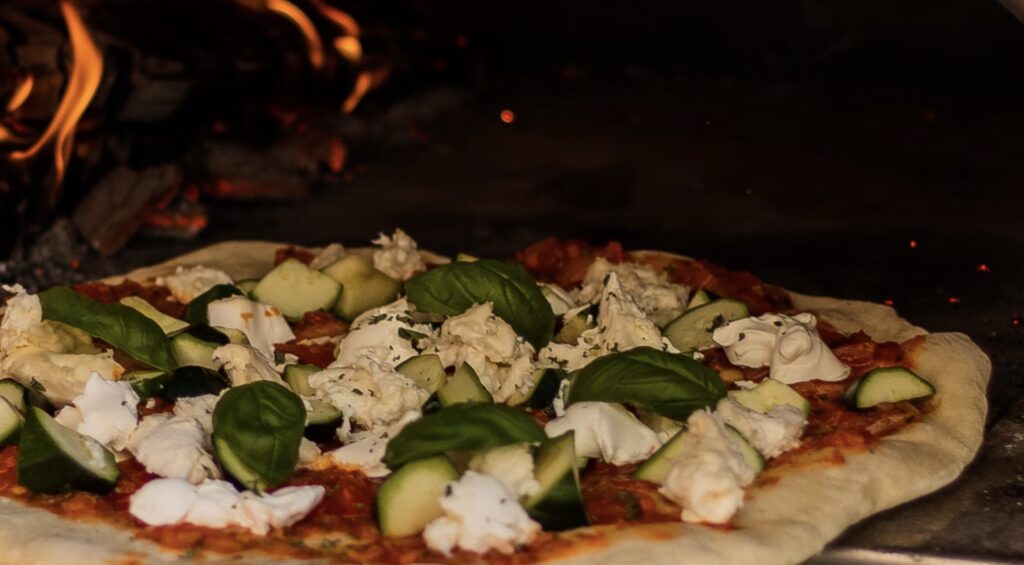Bag lækre, autentiske og sprøde pizzaer i en Cozze pizzaovn.
